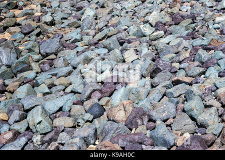 Pebbles on the beach in lovely shades of blue, grey and purple. Stock Photo