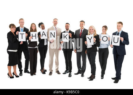 Full length portrait of smiling business team holding Thank You sign against white background Stock Photo
