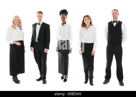 Full length portrait of confident multi ethnic restaurant staff standing against white background Stock Photo