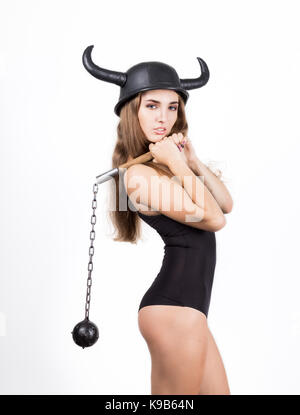 funny young woman in a swimsuit and helmet with horns holding mace Stock Photo