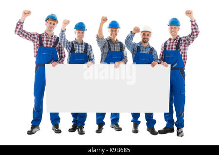 Full length portrait of male carpenters with arms raised holding blank billboard over white background Stock Photo