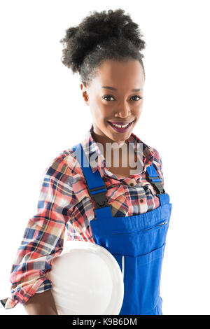 Portrait of smiling female carpenter holding hardhat standing against white background Stock Photo