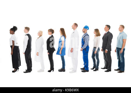 Full length side view of people with various occupations standing in queue against white background Stock Photo