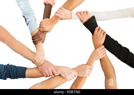 Directly above shot of people holding each other's hand in showing unity against white background Stock Photo