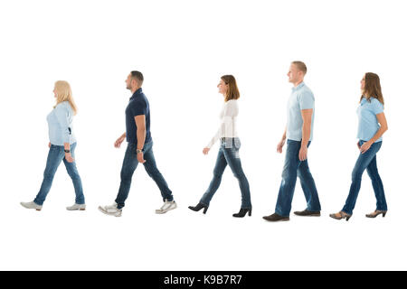 Full length side view of men and women walking in queue isolated on white background Stock Photo