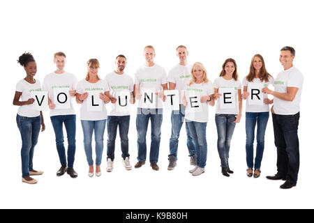 Full length portrait of confident volunteers holding blank placards against white background Stock Photo