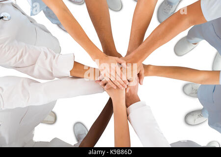 Directly above shot of medical team standing hands against white background Stock Photo