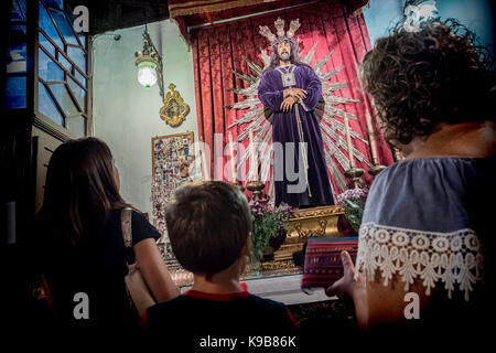 Andalusian family praying to Jesus in a church Stock Photo