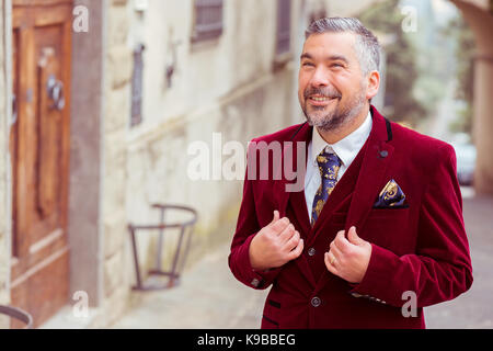 portrait of a middle age elegant business man standing outdoors on a old village street Stock Photo