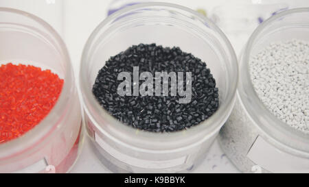Plastic granules on extruder for making plastics on extrusion manufactory - red, black and white Stock Photo