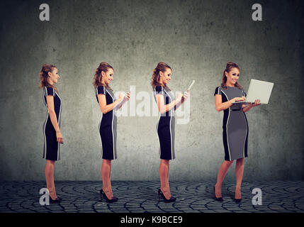 Modern digital devices and technology progress concept. Attractive business woman using mobile phone, tablet and laptop computer Stock Photo