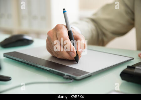 Close-up Of A Businessman Using Graphic Tablet In Office Stock Photo
