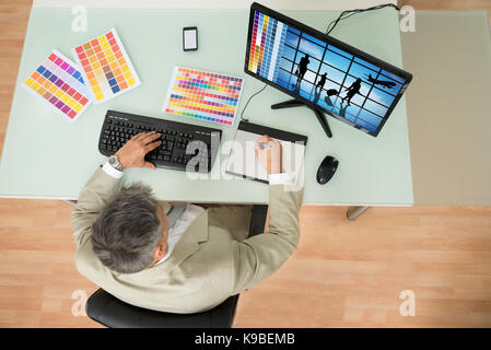 High Angle View Of Businessman Using Graphic Tablet In Office. Photographer owns copyright for images on screen Stock Photo