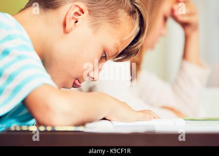 Girl and boy doing their homework for elementary school. Stock Photo