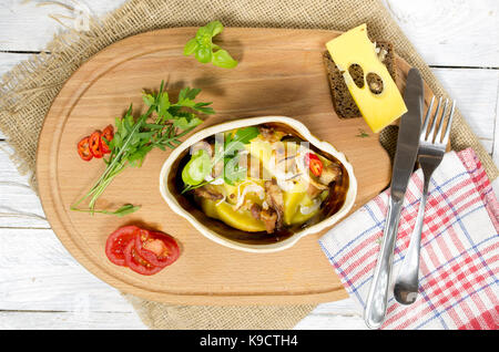 Baked potatoes with bacon. Potatoes at home. Potato with greens and vegetables. Stock Photo