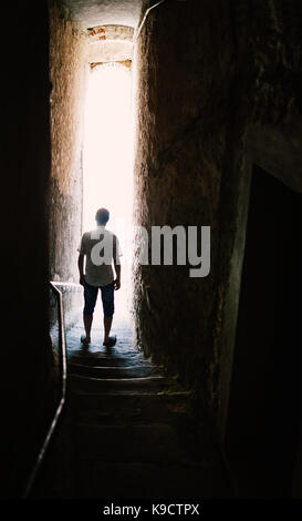 Man silhouette on stairs in narrow street. Mysterious concept Stock Photo