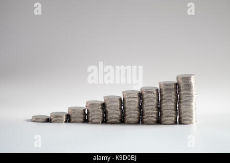 stacks of coins in ascending numbers from left to right symbolizing growing or increasing wealth, investments, savings, riches or general improvement Stock Photo