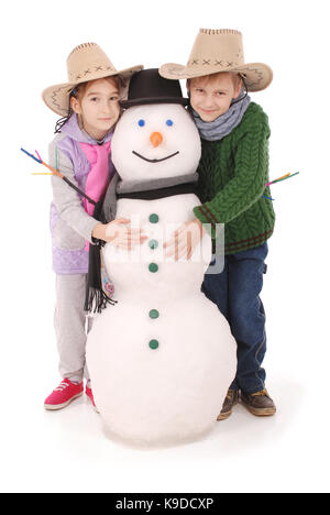 Cute boy and girl with snowman with scarf and hat on white background Stock Photo