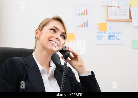 Portrait Of Young Happy Businesswoman Using Telephone Stock Photo