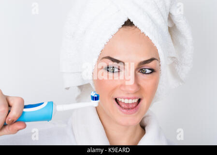 Smiling Woman In Bathrobe Holding Toothbrush With Toothpaste Stock Photo