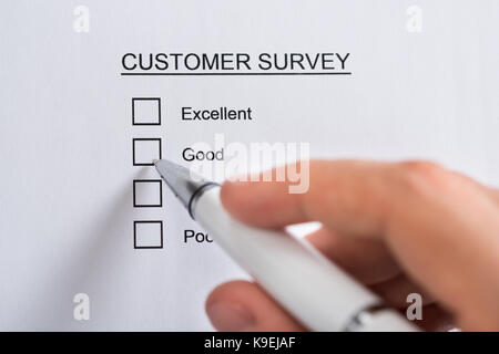 Close-up Of Person Hands With Pen Filling Customer Survey Blank Form Stock Photo
