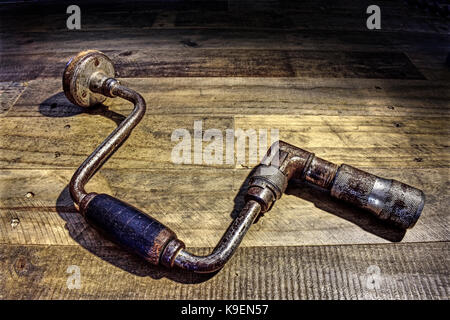 Carpentry drill. Old. Wooden background. Stock Photo