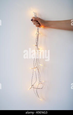 Christmas lights in hand on white background Stock Photo
