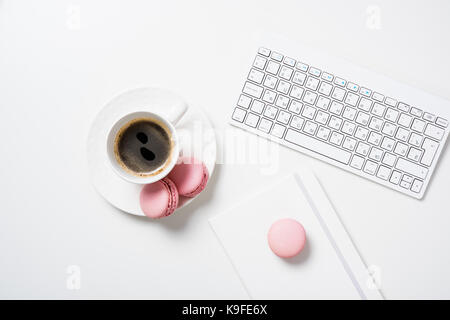 Social media flat lay with coffee, pink macaroons and flowers on white background Stock Photo