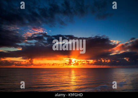 Storm clouds clearing at sunset create drama over the Pacific Ocean Stock Photo