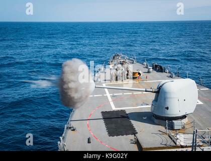 The Arleigh Burke-class guided-missile destroyer USS Mitscher (DDG 57) fires its Mark 45 5-inch gun Stock Photo