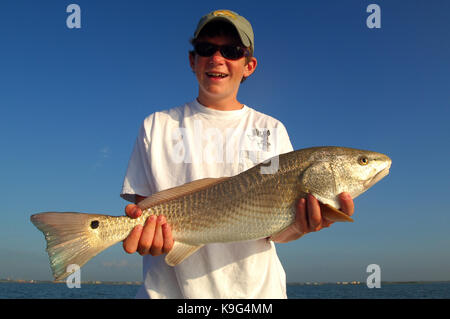 A young boy with a redfish or red drum caught while fishing near Port Aransas Texas Stock Photo