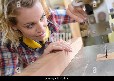 female carpenter working on woodboard Stock Photo