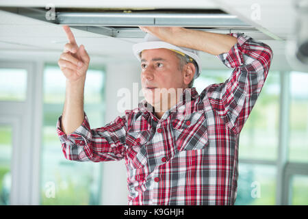 electrician working on ceiling installation Stock Photo