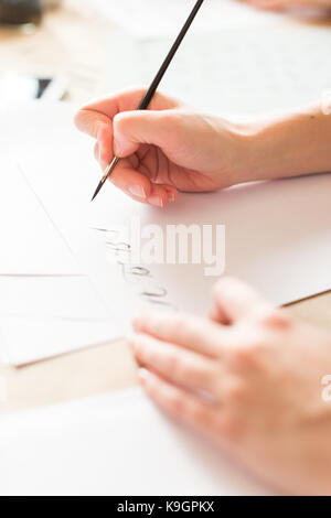 penmanship, hobby, graphic design concept. well groomed hands of young caucasian woman who writing letters of russian alphabeth in harmonious and aest Stock Photo