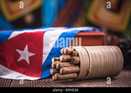 Cuban cigar in ashtray on wooden table, items related to travel to Cuba. Stock Photo