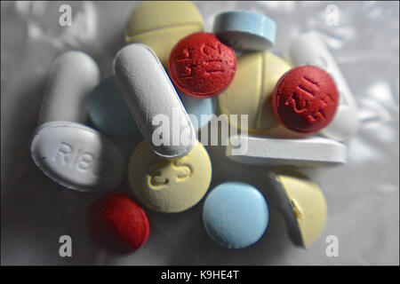 macro shot in low light of a handful of pills: prescription pain relievers, anxiolytics, antidepressants, stimulant decongestant, and a muscle relaxer Stock Photo