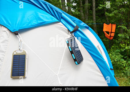 Hiking hand-held portable batteries with solar panels on tent Stock Photo