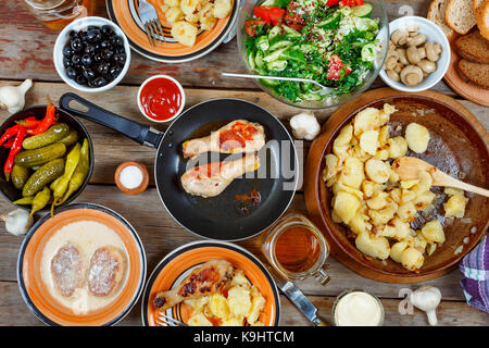 various Traditional American snacks with grilled chicken legs and fried potatoes on the dining table. View from above. Concept of eating outdoors on a Stock Photo
