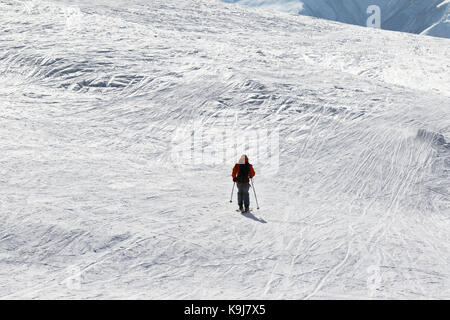 Skier downhill on snow off-piste slope in sun winter day. Caucasus Mountains, Georgia, region Gudauri. Stock Photo