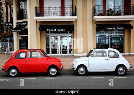 Menton, France - May 14, 2016: Two small Italian cars Fiat 500 Parked in a Parking Lot in Menton. The red car is a Fiat 500 R and the white is a Fiat  Stock Photo