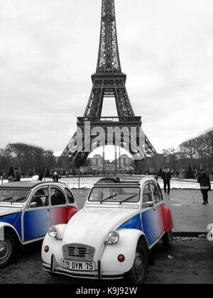 Paris, France - March 13, 2013: 2CV Cocorico Tricolor Cars. Two Citroen 2CV Parked on Front of the Eiffel Tower in Paris, France Stock Photo