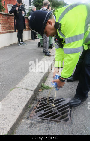London, UK. 23rd Sep, 2017. A police officer pours cans of Beer down the drain which was confiscated from football fans ahead of the Sky bet championship match between Middlesborough and Fulham at Craven Cottage West London Credit: amer ghazzal/Alamy Live News Stock Photo