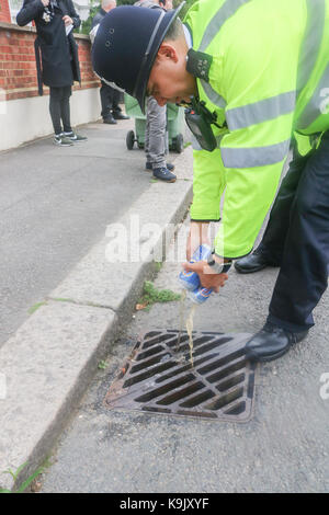 London, UK. 23rd Sep, 2017. A police officer pours cans of Beer down the drain which was confiscated from football fans ahead of the Sky bet championship match between Middlesborough and Fulham at Craven Cottage West London Credit: amer ghazzal/Alamy Live News Stock Photo