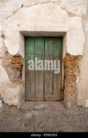 Old entrance from a rural house with a green wooden door. Stock Photo