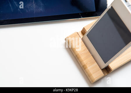 smart phone and tablet wireless charging on a white desk Stock Photo