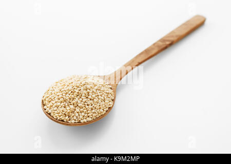 Quinoa in wooden spoon on white background Stock Photo