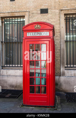 Young man in a red phone booth, London, England, Great Britain Stock Photo