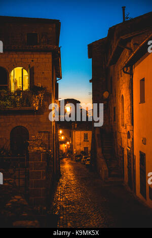 Narrow illuminated alleyway in the old town, night scene, Orvieto, Umbria, Italy Stock Photo