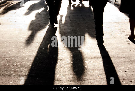 Defocused shadow and silhouette of people on city sidewalk in black and white Stock Photo