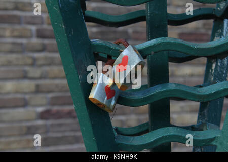 Two love locks locked on an iron ornament of a bridge Stock Photo